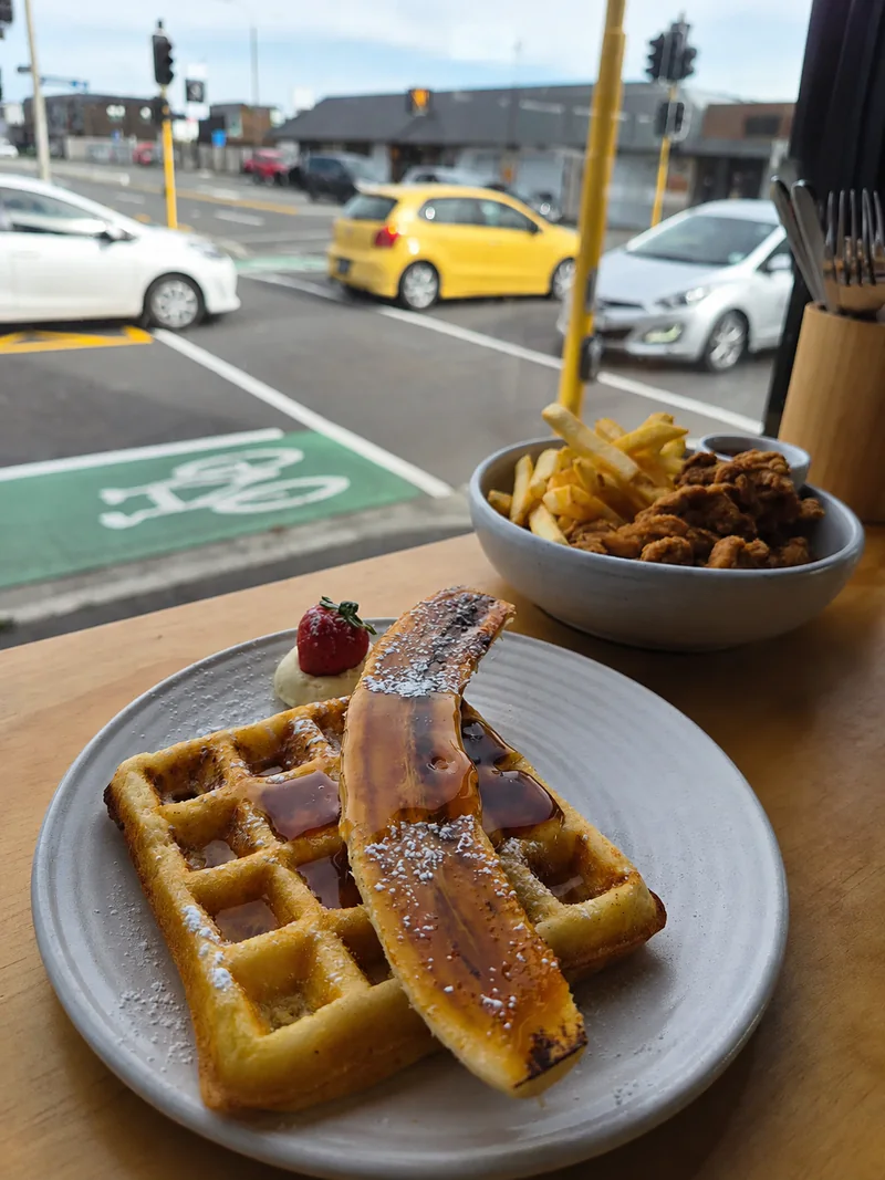 Waffles with banana and maple syrup beside the café window